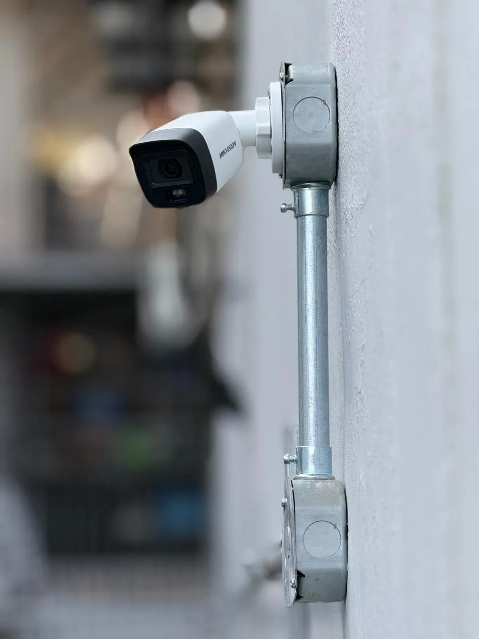 Cámara de seguridad instalada con tubería en una fachada