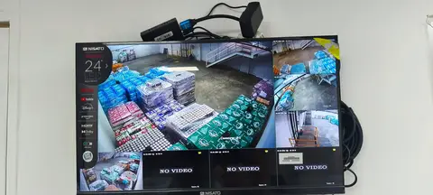 Monitor con vista de cámaras de un almacén con paletas de bebidas embaladas