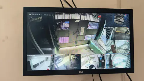 Monitor con cámaras de la entrada, portón y estacionamiento de un edificio residencial