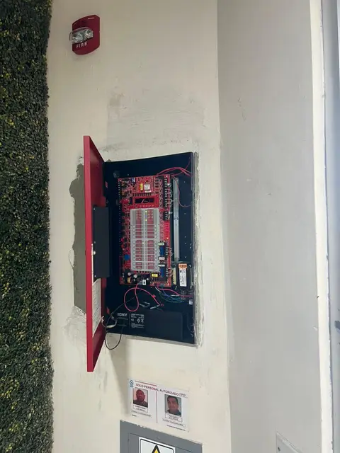 Panel de control de alarma contra incendios con batería de respaldo instalado en pared