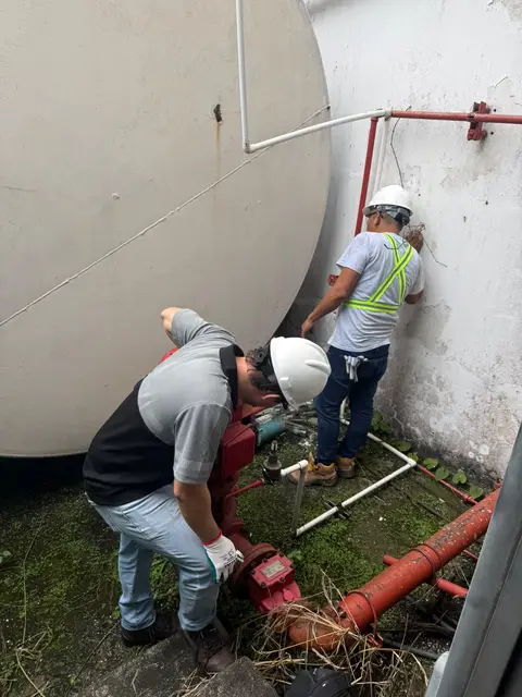 Técnicos dando mantenimiento a válvulas y tubería del tanque contra incendios