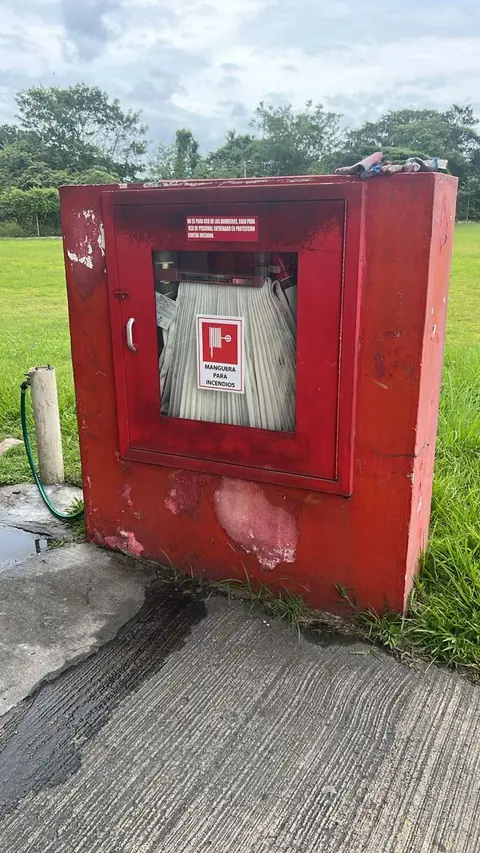 Gabinete de manguera contra incendios con manguera enrollada, antes de mantenimiento